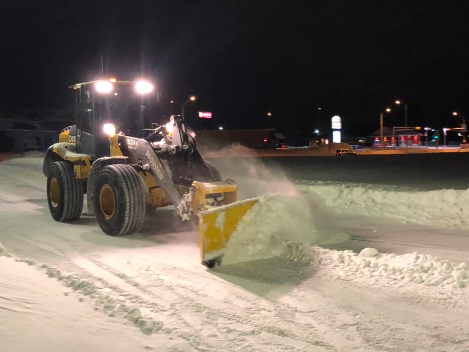 Snow Plowing tractor plowing in parking lot
